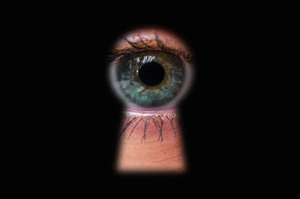 olho humano por trás olhando através de um buraco de fechadura de porta - keyhole peeking human eye curiosity - fotografias e filmes do acervo