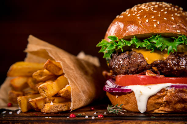 istock Tasty burger on wooden table. 1128882377