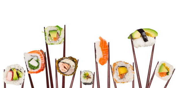 istock Traditional japanese sushi pieces placed between chopsticks, separated on white background. 1128884320