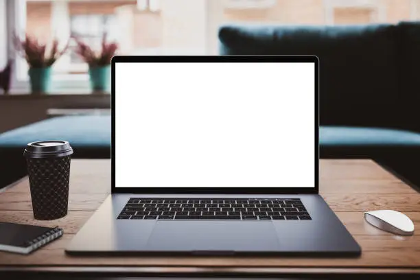 Photo of Laptop with blank screen on table in office loft interior building