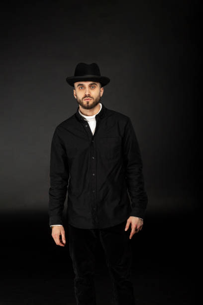 istock Handsome young model wearing in black shirt and hat 1128886152