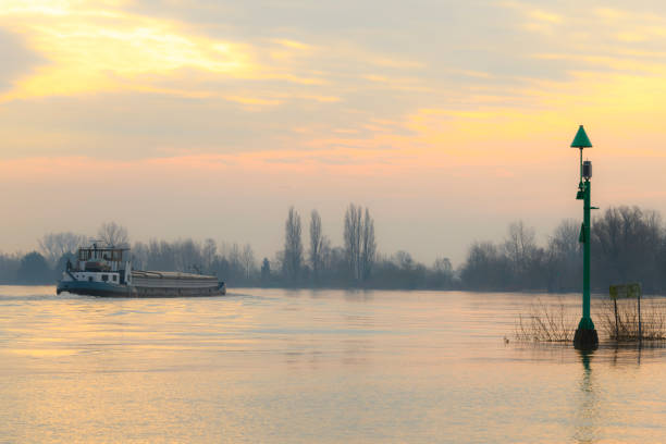 Flooding in the overflow area of the river IJssel in  The Netherlands with a barge freight ship passing in the morning