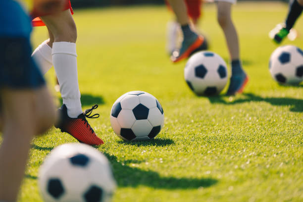 soccer football training for children. kids playing soccer on training football pitch. beginner soccer drills for kids. coach in the background coaching youth soccer - equipamento náutico imagens e fotografias de stock