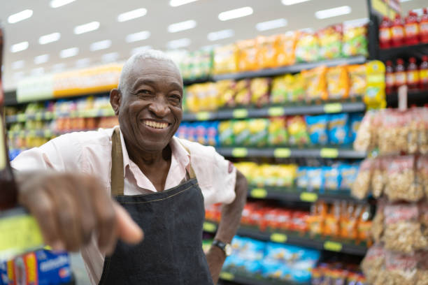 dueño de negocio de hombre senior afro / empleado en supermercado - trabajador manual fotografías e imágenes de stock