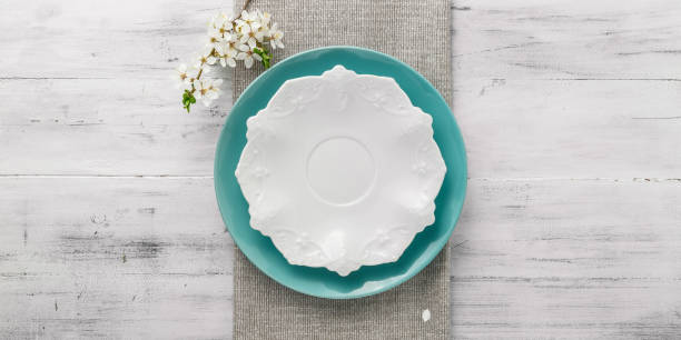 tavolo primaverile con piatti e fiori bianchi - plate blue dishware white foto e immagini stock