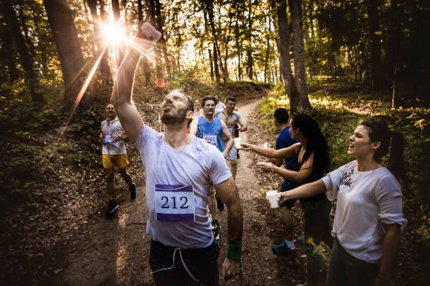 istock Athletic man pouring water on himself while participating in marathon race in nature. 1128889467