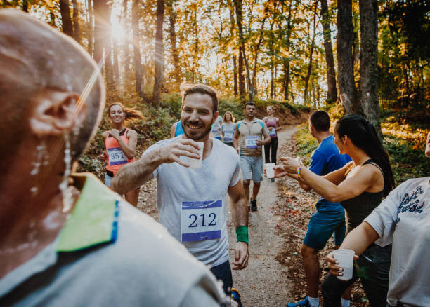 Athletic people running a marathon and refreshing themselves with water.
