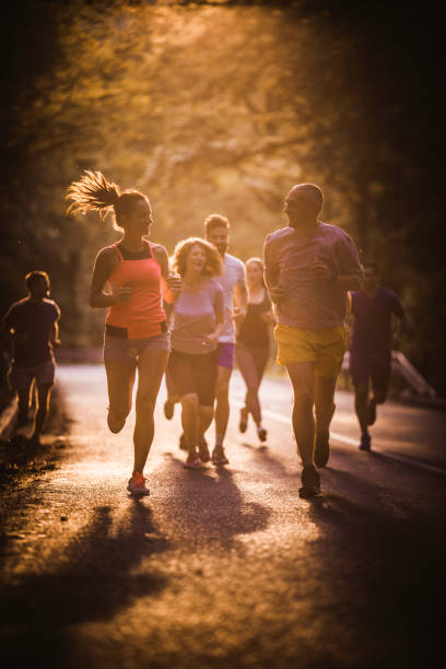 istock Athletic people talking while taking part in marathon race at sunset. 1128890060