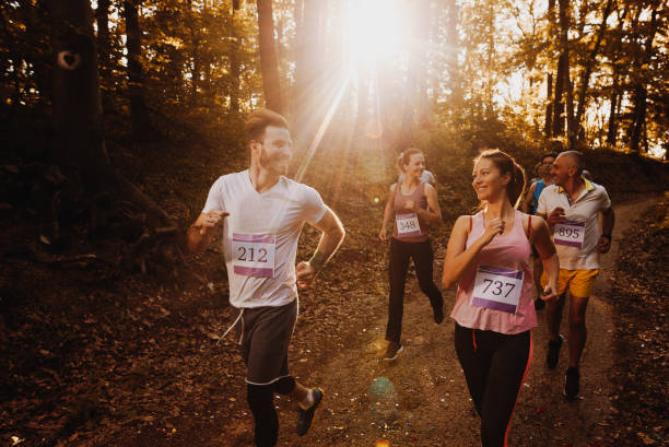 istock Happy athletic couple talking while participating in marathon race in the forest. 1128890559