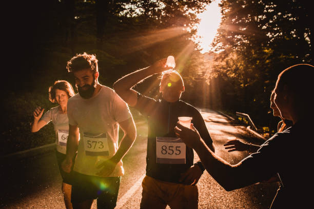 istock Marathon runner refreshing himself while pouring water on the face at sunset. 1128891062