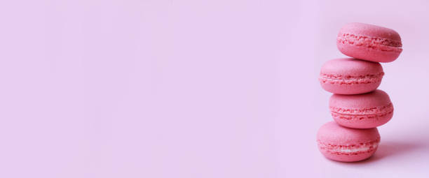 istock Four pink macaroons on a light pink background, sweet minimal food concept 1128891904