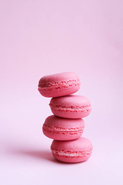 istock Four pink macaroons on a light pink background, sweet minimal food concept 1128891907
