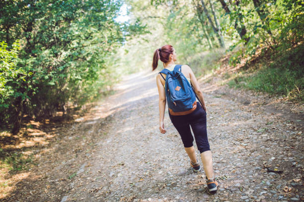 istock Backpacker woman walking into the forest. 1128892172
