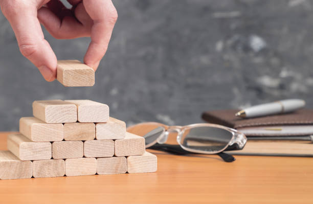 istock Business concept. Male hand puts a wood block stacking 1128893874