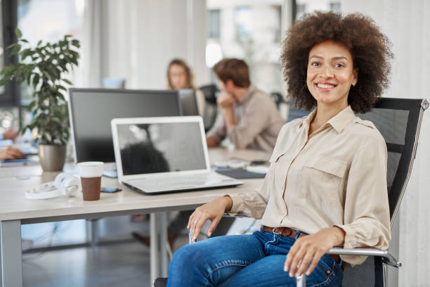 istock Smiling mixed race CEO sitting at office. 1128895272