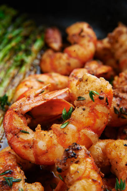 istock fried langoustines with asparagus decorated with lemon slices. roasted king prawns tiger shrimps with green garnish 1128896191