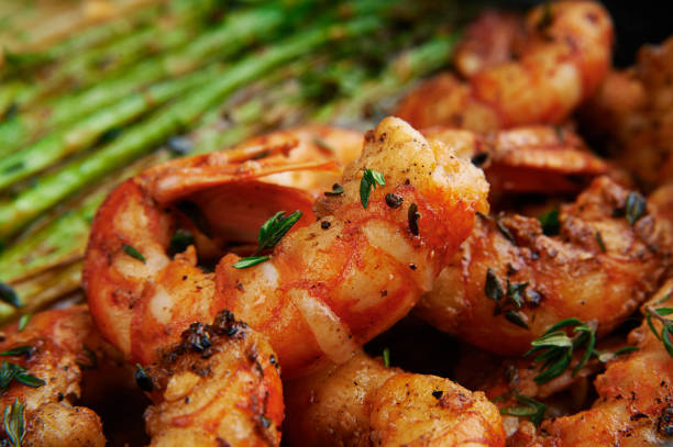 istock fried langoustines with asparagus decorated with lemon slices. roasted king prawns tiger shrimps with green garnish 1128896201