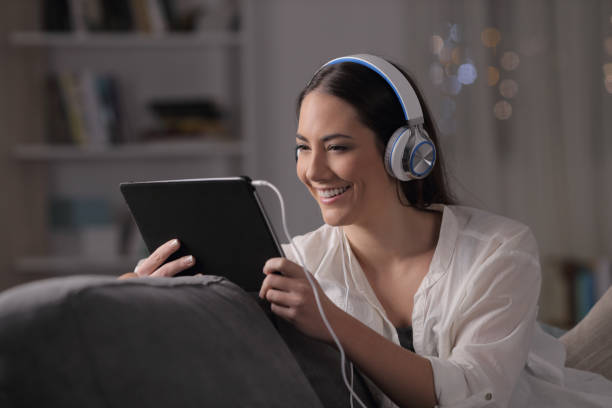 istock Happy woman watching and listening tablet content 1128899446