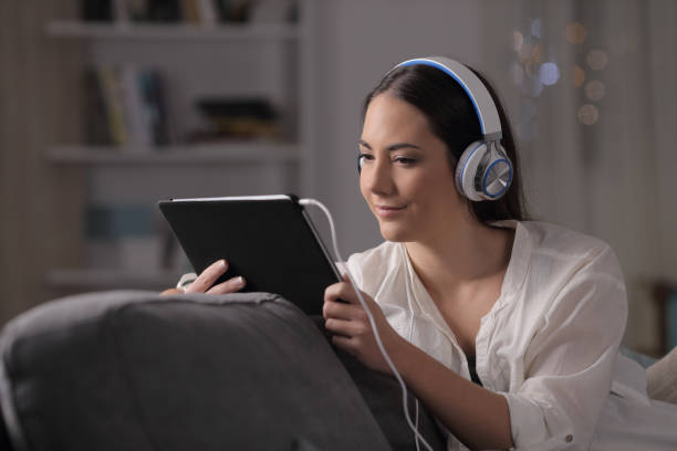 istock Serious woman watching and listening tablet content 1128899716