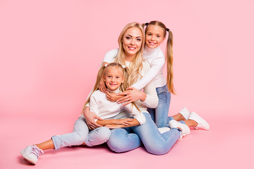 Portrait of nice-looking cute attractive charming cheerful cheery stylish people mom mum sitting cuddling spending free time isolated over pink pastel background