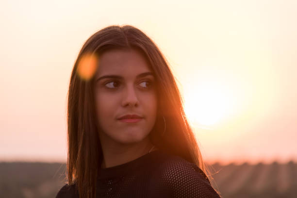istock young brunette girl posing at field 1128905388