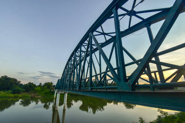 istock Scenery with sun behind the iron bridge across the river 1128905942