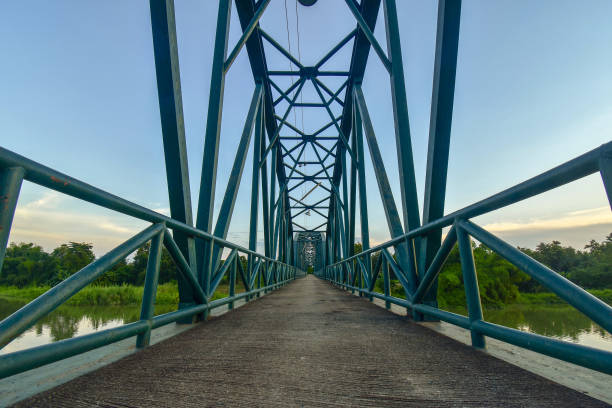 istock Scenery with sun behind the iron bridge across the river 1128905970