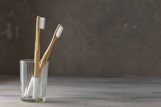istock Two eco friendly bamboo tooth brushes in a glass 1128906274