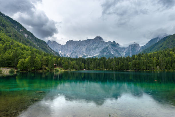 fusine see und alpen - friaul-julisch venetien-italien - cloud day friuli venezia giulia pine tree stock-fotos und bilder