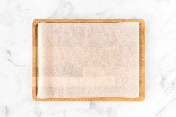 istock Wooden Cutting Board with Parchment on White Marble 1128908026
