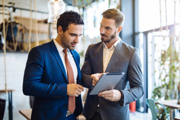 istock Two young businessmen discussing business strategy using digital tablet 1128909177
