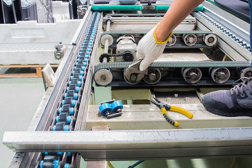 trabajador reparación y mantenimiento de cinta transportadora en fábrica photo