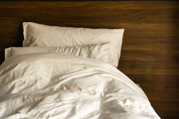istock white pillows and blanket with wooden wall on the background 1128910792