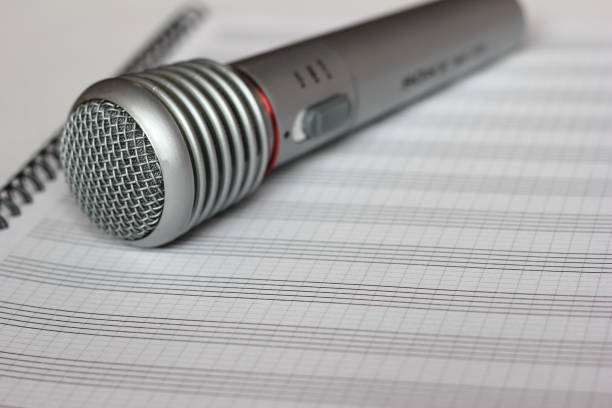 istock The musical microphone lies on a clean sheet music. 1128911118