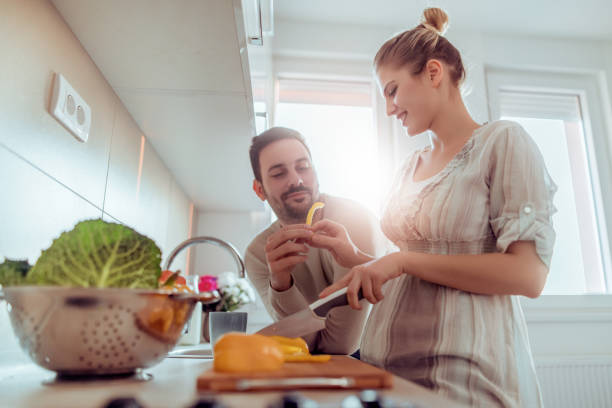 istock Young couple smiling while cooking healthy food 1128911187