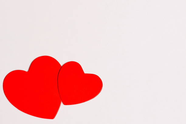 istock Valentines Day. Two red cardboard hearts are arranged together on a white background. Concept of love. Copy Space. 1128911202