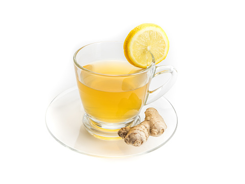 A pitcher of ice tea and glass with lemon, in a kitchen window setting. Light breezy summer feel.