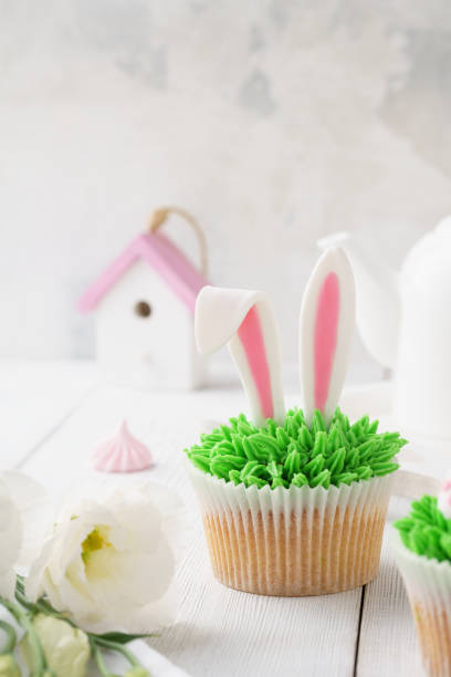 istock Easter cupcake decorated with bunny ears for dessert and flowers 1128912159