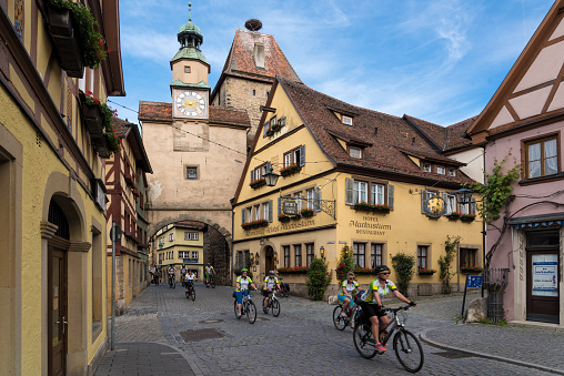 A group of men and women ride their bicycles in the narrow streets of Rothemburg ob der Tauber in Bavaria, Germany on May 27, 2018