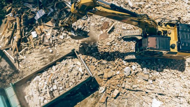 istock Digger placing construction waste of demolished building onto a truck 1128913464