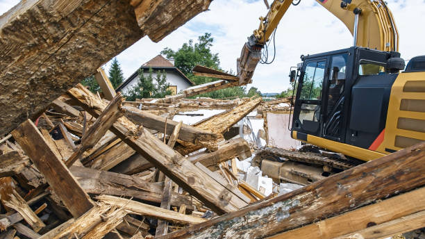 istock Digger tipping over outer walls of building being demolished 1128913507