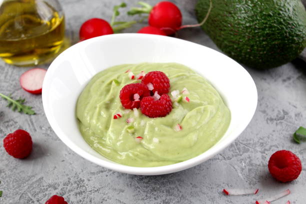 istock Homemade avocado smoothie served with raspberries on light background. 1128913786
