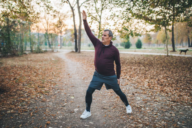 istock Senior man in sport clothing stretching 1128914200