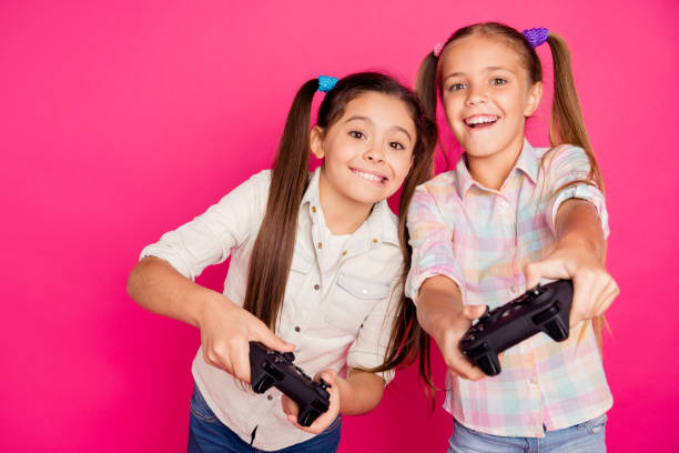 cercana a personas de la foto dos pequeña edad ella mantenga sus chicas manos brazos tratando de ganar juego no perder ganador perdedor desgaste jeans casuales del dril de algodón a cuadros camisas cuadros aislados rosa vibrante viva fondo - video game friendship teenager togetherness fotografías e imágenes de stock