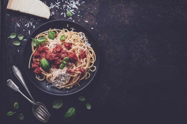 istock delicious appetizing classic spaghetti pasta with tomato sauce, parmesan cheese and fresh basil, top view 1128915546
