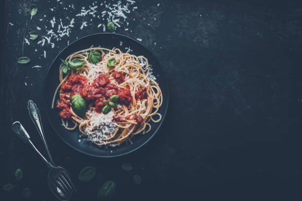 istock delicious appetizing classic spaghetti pasta with tomato sauce, parmesan cheese and fresh basil, top view 1128915547