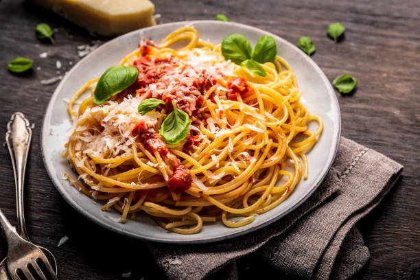 istock delicious appetizing classic spaghetti pasta with tomato sauce, parmesan cheese and fresh basil, top view 1128915654