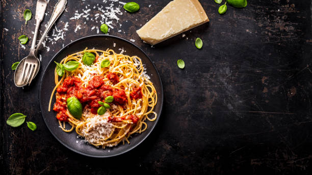 istock delicious appetizing classic spaghetti pasta with tomato sauce, parmesan cheese and fresh basil, top view 1128915774