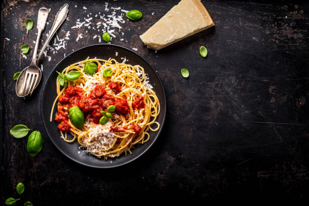 pasta deliciosos espaguetis clásicos apetitosa con salsa de tomate, queso parmesano y albahaca fresca, vista superior - queso fotos fotografías e imágenes de stock