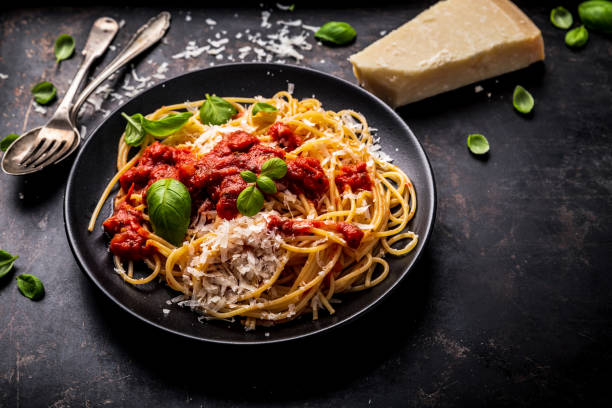 istock delicious appetizing classic spaghetti pasta with tomato sauce, parmesan cheese and fresh basil, top view 1128915894
